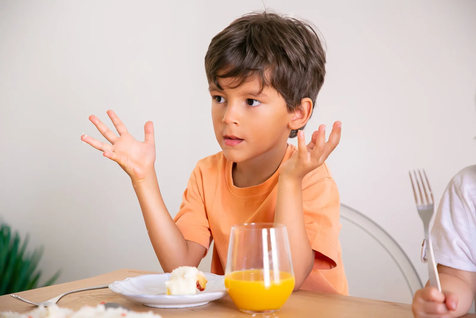 Mother encouraging her child to eat a healthy meal while a pediatrician explains common causes of poor appetite in children.