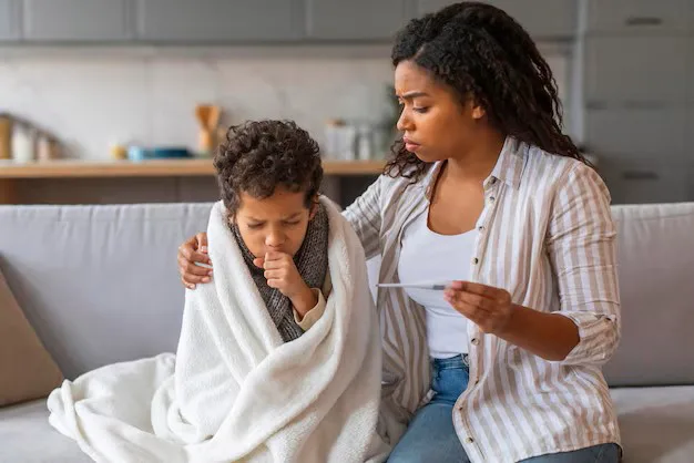 Mother comforting her child who has a persistent cough while monitoring symptoms at home.